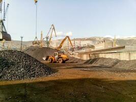 Cargo industrial port, port cranes. Loading of anthracite. Transportation of coal. Heap of coal photo