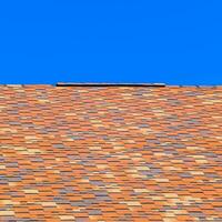 Roof from multi-colored bituminous shingles. Patterned bitumen shingles. photo