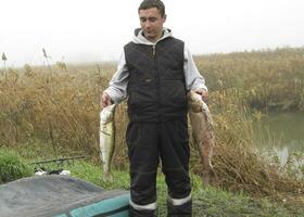 The fisherman is holding his catch. Silver carb and perch. photo