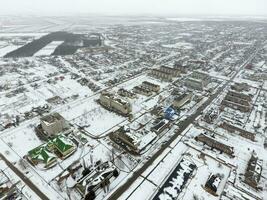 invierno ver desde el aves ojo ver de el aldea. el calles son cubierto con nieve foto