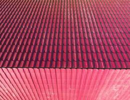 A house with a red roof made of corrugated metal sheets. Roof from corrugated metal profile. Metal tiles. photo