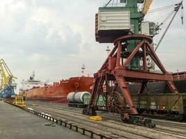 Loaded freight cars in the port. Passage of cars under the tower photo