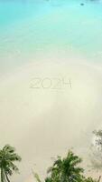 The year 2024 written on a tropical beach. Concept of a beach getaway in 2024. video