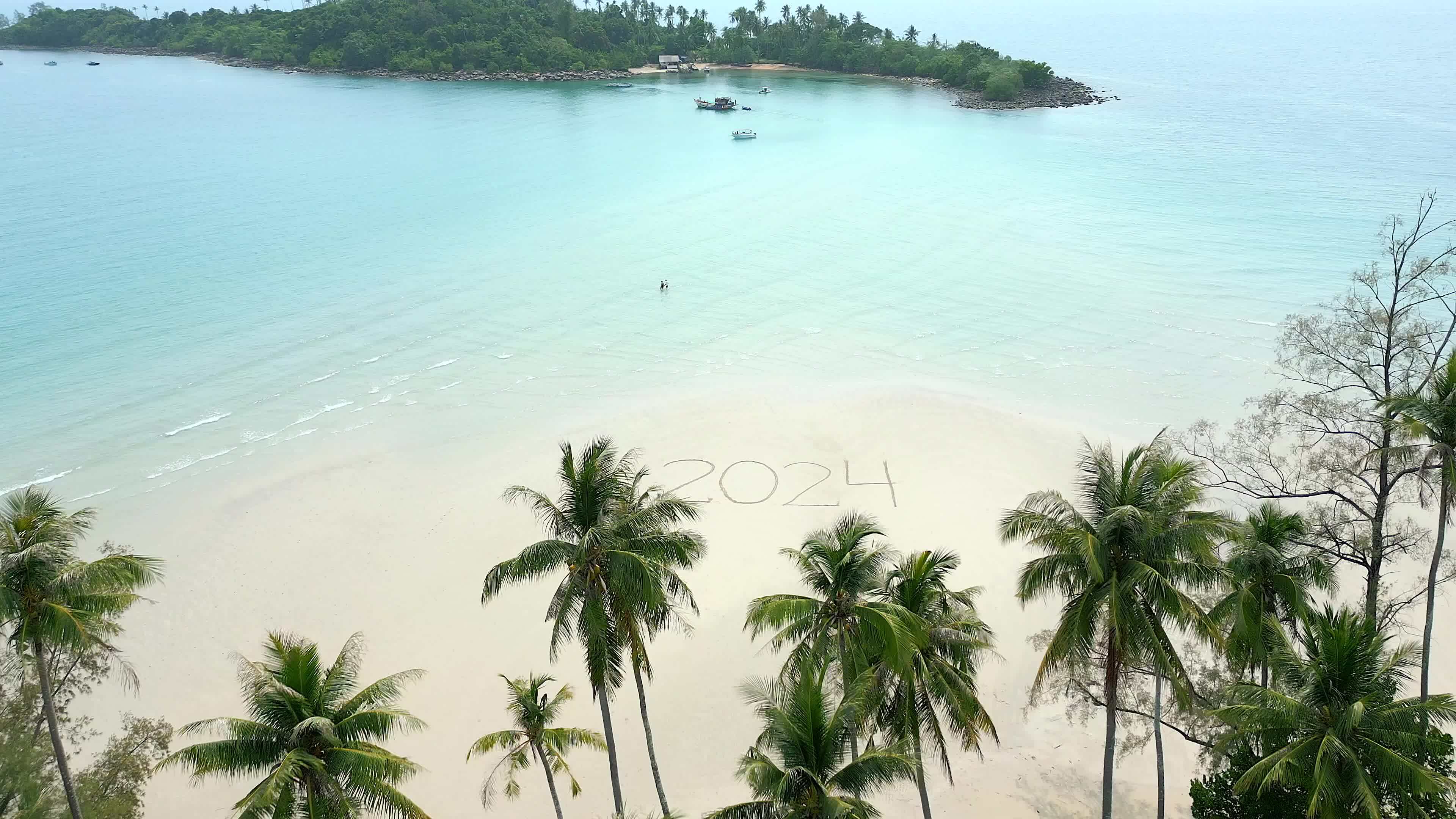The year 2024 written on a tropical beach. Concept of a beach getaway