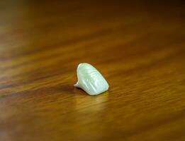 Tooth, metal ceramic crown on the table. Denture made of metal ceramics photo