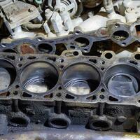 The cylinder block of the four-cylinder engine. Disassembled motor vehicle for repair. Parts in engine oil. Car engine repair in the service photo