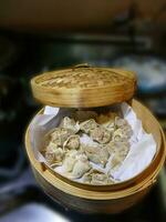 Steaming shumai dim sum in a bamboo steamer photo