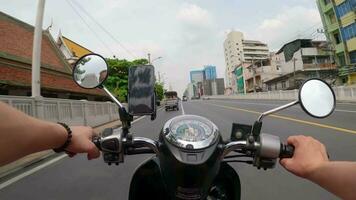 hiperlapso de scooter montando detrás un tuk tuk en el la carretera en bangkok, Tailandia video