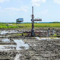 Oil well after repair in mud and puddles. photo
