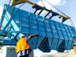 Raising the hopper car for unloading on a cargo ship. Lifting operations in the port. photo