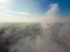 The smoke over the village. Clubs of smoke over the village houses and fields. Aerophotographing areas photo
