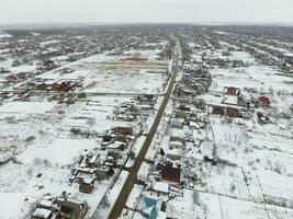 invierno ver desde el aves ojo ver de el aldea. el calles son cubierto con nieve foto