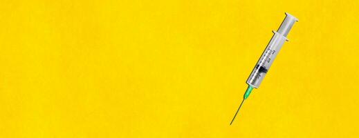 Syringe on the yellow background photo