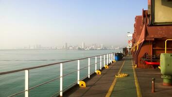 View of the sea and city beach from the port quay. Industrial port with tower cranes and cargo infrastructure photo