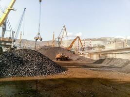 Cargo industrial port, port cranes. Loading of anthracite. Transportation of coal. Heap of coal photo