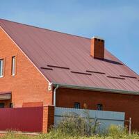 Detached house with a roof made of steel sheets. photo