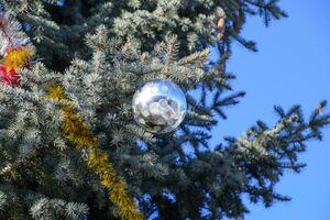 decoraciones nuevo año árbol. oropel y juguetes, pelotas y otro decoraciones en el Navidad Navidad árbol en pie en el abierto aire. foto