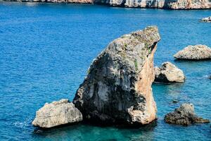 Limestone cliffs by sea. Waves beat on the rocks. photo