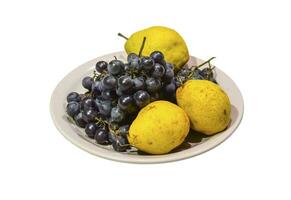 amarillo Pera y uvas en el plato foto