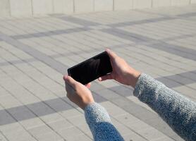 un teléfono inteligente es en el manos de un mujer. comunicación utilizando un teléfono inteligente foto