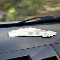 Dollars on a car dashboard under the windshield. American Money photo