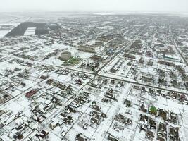 invierno ver desde el aves ojo ver de el aldea. el calles son cubierto con nieve foto