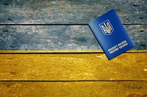 Ukraine passport on the table and flag photo
