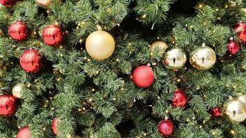 Close-up of a twinkling Christmas tree with lots of colorful baubles and lights . video