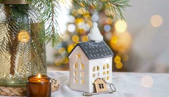 Key and tiny house of a small size on cozy home with Christmas decor on table of festive kitchen. Gift for New Year. Insurance, moving to new house, mortgage, rent and purchase real estate photo