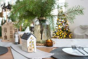 Key and tiny house of a small size on cozy home with Christmas decor on table of festive kitchen. Gift for New Year. Insurance, moving to new house, mortgage, rent and purchase real estate photo