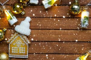 Tiny gingerbread house on wooden background with Christmas decor layout and copy space. Gift for New Year, Christmas. Building, project, moving to new house, mortgage, rent and purchase real estate photo