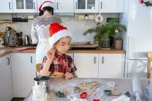 Mom and daughter in the white kitchen are preparing cookies for Christmas and new year. Family day, preparation for the holiday, learn to cook delicious pastries, cut shapes out of dough with molds photo