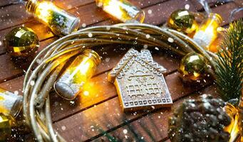 Tiny gingerbread house on wooden background with Christmas decor layout and copy space. Gift for New Year, Christmas. Building, project, moving to new house, mortgage, rent and purchase real estate photo