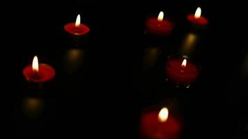 Burning candles on dark surface. Memory day. Red candles glowing in the dark. video