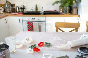 Layout of cookie cutters close-up cut out cookies from the dough with molds on a Christmas theme in the form of a snowman, a Christmas tree, stars in the kitchen photo