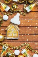 Tiny gingerbread house on wooden background with Christmas decor layout and copy space. Gift for New Year, Christmas. Building, project, moving to new house, mortgage, rent and purchase real estate photo