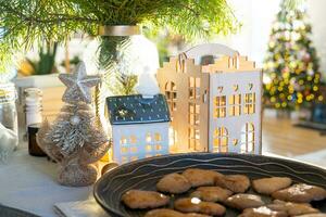 decoración navideña festiva en la mesa, pasteles caseros para el desayuno, galletas de panadería. hogar acogedor, árbol de navidad con guirnaldas de luces de hadas. año nuevo, estado de ánimo navideño foto