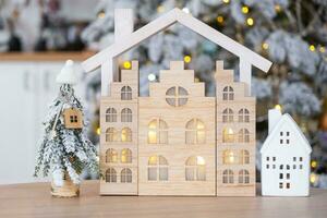 llave en Navidad árbol y minúsculo casa en acogedor hogar con Navidad decoración en mesa de festivo blanco cocina. regalo para nuevo año. seguro, Moviente a nuevo casa, hipoteca, alquilar y real inmuebles foto