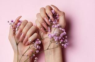 hembra manos con hermosa manicura en rosado antecedentes foto