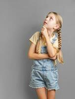 Portrait of a little girl with braided hair who is thinking photo