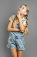 Portrait of a little girl with braided hair who is thinking photo