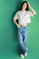 Full length portrait of a young girl in a white T-shirt and jeans. photo