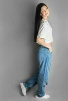 Full length portrait of a young girl in a white T-shirt and jeans. photo