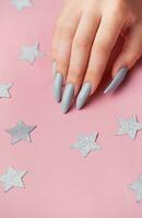 Hands with grey manicure on a pink background photo