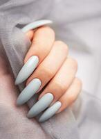 Grey nails on grey lace background. photo