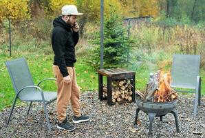 A man lights a barbecue in nature photo