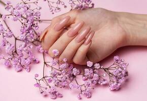 Female hands with beautiful manicure on pink background photo