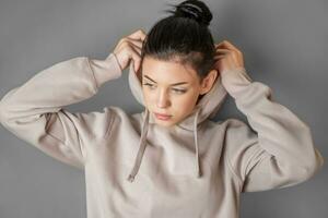 Pensive thoughtful young girl wearing sweatshirt with hood photo