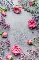 Colored gypsophila flowers and pink roses on concrete background photo