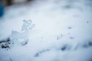 Christmas toy deer in the snow. Christmas card. Winter background. photo